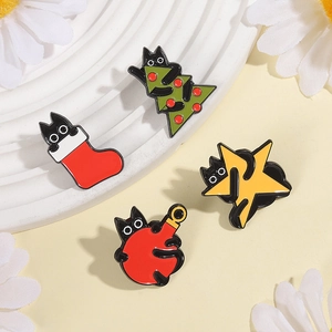 Dettaglio di quattro spille in smalto con gatto nero e motivi festivi di Natale e stelle