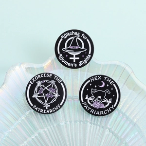 Feminist witch enamel pins set displayed on a seashell tray with mystic moon patterns