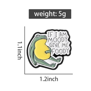 Detailed view of moody frog enamel pin with foody text and measurement markers