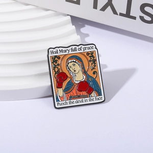 Boxing Virgin Mary enamel pin with Hail Mary text on a white minimalist display stand