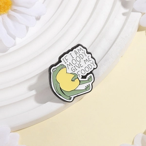Funny green frog enamel pin with 'If I Am Moody Give Me Foody' text and floral decor