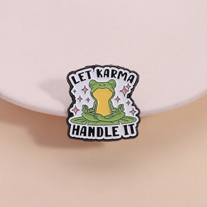 Funny green frog meditation enamel pin with Let Karma Handle It slogan on pink base
