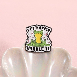 Funny green frog meditation enamel pin with Let Karma Handle It slogan on pink background