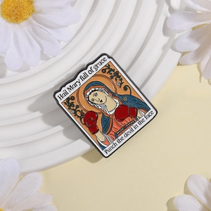 Virgin Mary enamel pin with boxing gloves featuring humorous text on white display tray