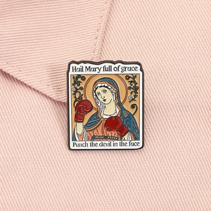 Detail of creative Virgin Mary boxing enamel pin on pink fabric background