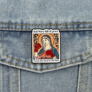 Virgin Mary tarot card enamel pin with boxing gloves on blue denim jacket pocket