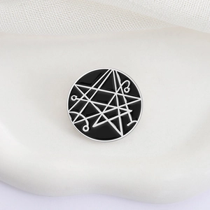 Minimalist black and white enamel lapel pin with geometric occult pattern design