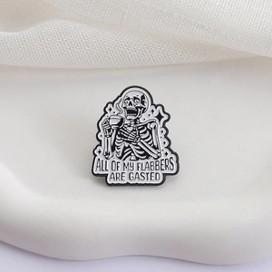 Detailaufnahme einer Emaille-Anstecknadel mit kaffeetrinkendem Skelett auf Keramikgrund