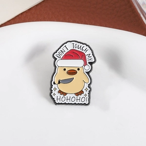 Close-up of enamel duck pin wearing a Santa hat and holding a knife with Don't Touch My text