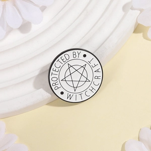 Close-up of circular enamel pin featuring a pentagram and Protected by Witchcraft text