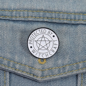 Detail of Protected by Witchcraft enamel pin with pentagram on denim jacket