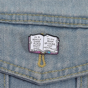 Colorful book enamel pin with inspirational English quotes on blue denim jacket