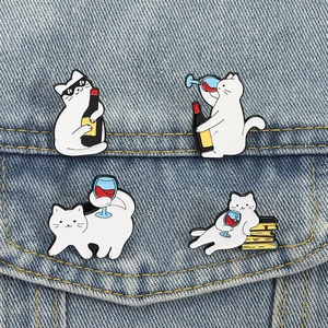 Set mit vier weißen Katzen-Emaille-Pins zum Thema Wein auf einer blauen Jeansjacke