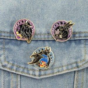 Gothic mystic pins with owl, black cat, and bat designs on blue denim fabric background