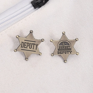 Close-up of vintage metal star badges with DEPUTY lettering on canvas background