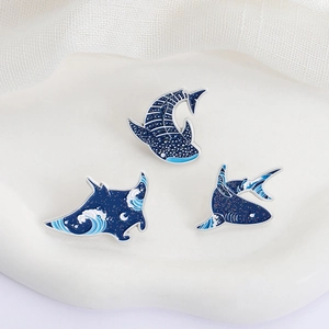 Three enamel pins with shark and whale motifs featuring Japanese Great Wave art designs
