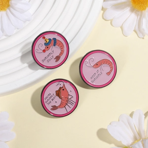 Primer plano detallado de tres pines de esmalte de camarones rosa en un soporte decorativo