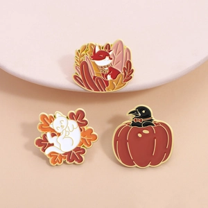 Set of autumn enamel pins featuring fox, cat with maple leaf, and crow in pumpkin designs