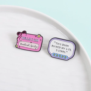 Funny bookish enamel pins featuring 'This Book Ruined My Life' and 'Bookish Girlie' quotes