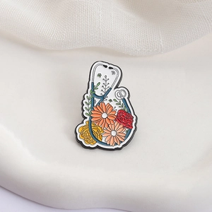Enamel stethoscope brooch with colorful flowers on a white textured background