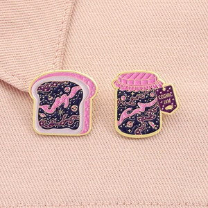 Detail of Cosmic Jam and toast enamel pins with gold trim and glitter stars