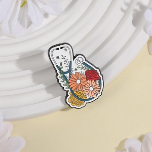 Kreative Stethoskop-Brosche mit buntem Blumen-Emaille-Design auf weißem Sockel