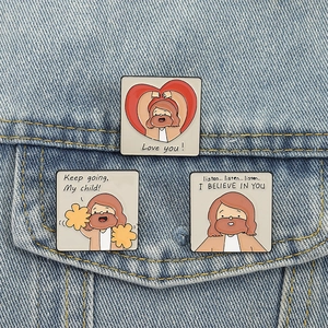 Detail of square cartoon Jesus enamel pins with inspirational text on denim jacket
