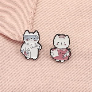 Detail of cute enamel cat pins featuring doctor and nurse designs on pink fabric