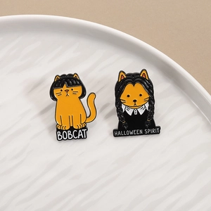 Halloween cat enamel pins with Bobcat and Halloween Spirit text on a ceramic plate
