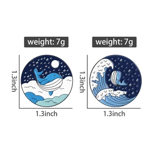 Detail view showing 1.3 inch ocean whale enamel pins with waves and starry sky patterns