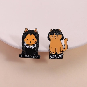 Halloween spirit enamel cat brooches featuring Wednesday Addams and bobcat hairstyles