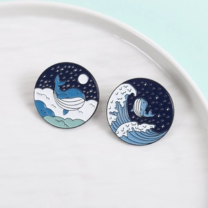 Enamel ocean whale brooch pins featuring night sky and sea waves on blue background