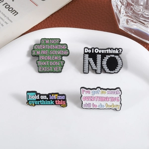 Set of four colorful enamel pins with humorous Overthinking quotes on a white plate