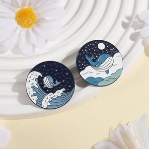 Set of ocean-themed enamel pins featuring whale, sea waves, and starry night sky patterns