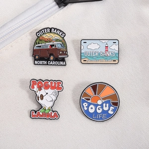 Set of four Outer Banks themed enamel pins including vintage bus and lighthouse designs