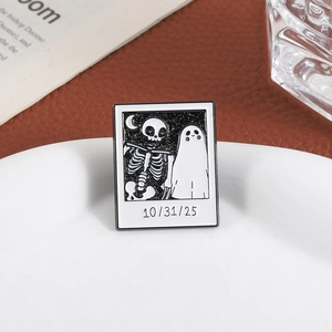 Halloween glitter enamel pin featuring a skeleton, ghost, and 10/31/25 date on ceramic