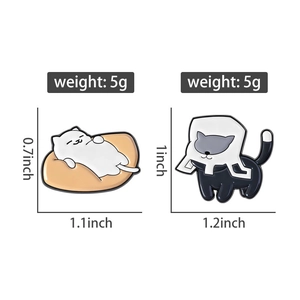 Detail view of cartoon cat enamel pins showing lazy cat and cat with cone neck collar