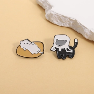 Cute enamel cat pins set featuring a lazy white cat on a cushion and a black cat in a box