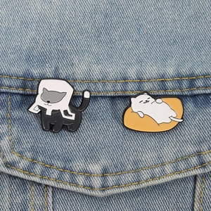 Cute cartoon cat enamel pins set featuring black and white cats on denim jacket