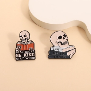 Gothic skull enamel pins with Read Books and Love Money Freedom text on books