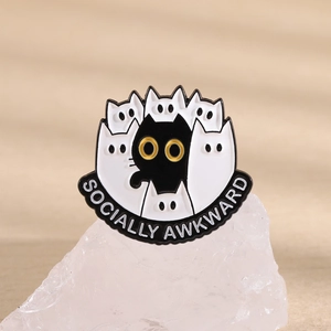 Macro d'une broche en émail sur le thème des chats avec texte sur cristal blanc