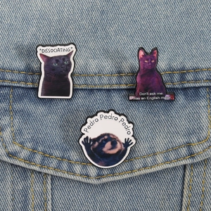 Three cute enamel pins set featuring black cats and Pedro raccoon on denim jacket