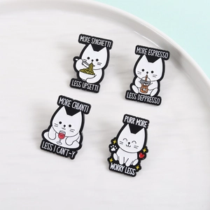 Detailed view of four funny cat enamel pins with puns on a white ceramic plate