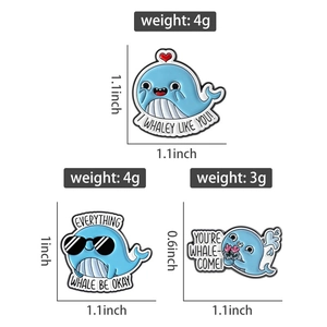 Three cute blue whale enamel pins with size and weight specs on a white background