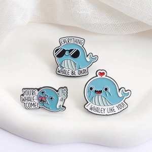 Three-piece set of cute blue whale enamel pins with funny puns on white plaster tray
