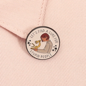 Macro shot of circular enamel pin with lab scientist and microscope on pink denim jacket
