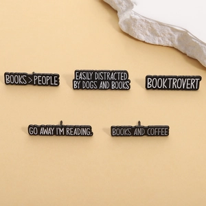 Five-piece black enamel book lover pins featuring witty reading and coffee phrases