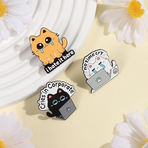 Three enamel pins featuring crying cats with humorous work quotes on light yellow background