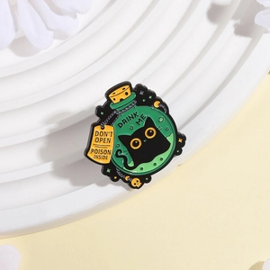 Detail of poison bottle enamel pin with black cat inside and DRINK ME text label