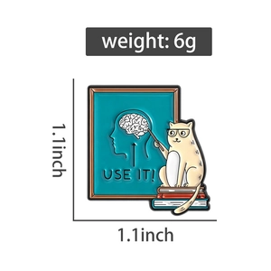 Detailansicht der Emaille-Anstecknadel Katze auf Büchern mit Use It Slogan und Maßen